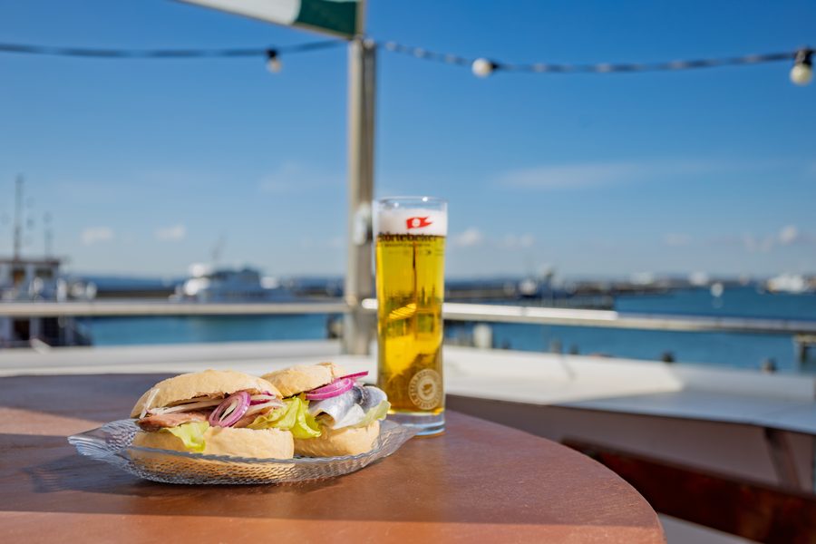 Fischbrötchen mit Störtebeker-Bier auf dem Sonnendeck mit Hafenblick